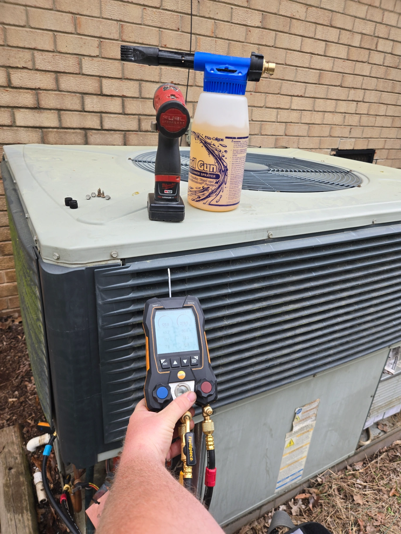 Dependable HVAC technician cleaning outdoor AC condenser coil in Albemarle NC