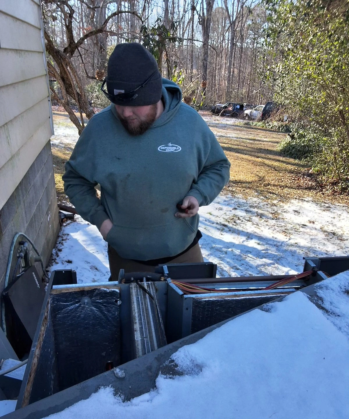 Outdoor HVAC unit service during winter maintenance
